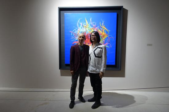 艺术家江衡（右）在展览现场